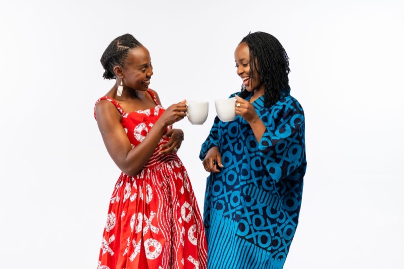 Fadzie and Musa laughing together and clinking mugs